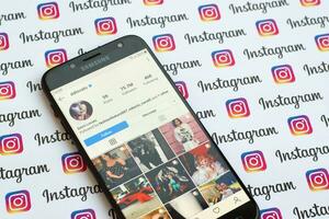 Demi Lovato official instagram account on smartphone screen on paper instagram banner. photo