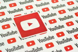 Youtube logo sticker on pattern printed on paper with small youtube logos and inscriptions. YouTube is Google subsidiary and American most popular video-sharing platform photo