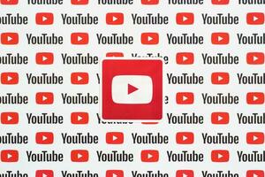 Youtube logo sticker on pattern printed on paper with small youtube logos and inscriptions. YouTube is Google subsidiary and American most popular video-sharing platform photo