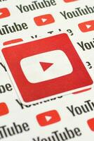 Youtube logo sticker on pattern printed on paper with small youtube logos and inscriptions. YouTube is Google subsidiary and American most popular video-sharing platform photo