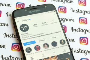 Tom Ford official instagram account on smartphone screen on paper instagram banner. photo