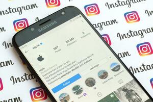 Apple official instagram account on smartphone screen on paper instagram banner. photo