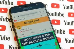 Bright Side official youtube channel on smartphone screen on paper youtube background. photo