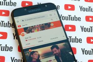 Zee TV official youtube channel on smartphone screen on paper youtube background. photo