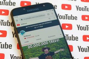 MrBeast official youtube channel on smartphone screen on paper youtube background. photo