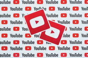 Youtube logo sticker on pattern printed on paper with small youtube logos and inscriptions. YouTube is Google subsidiary and American most popular video-sharing platform photo