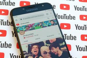 ElrubiusOMG official youtube channel on smartphone screen on paper youtube background. photo