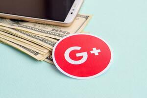 Google plus paper logo lies with envelope full of dollar bills and smartphone photo