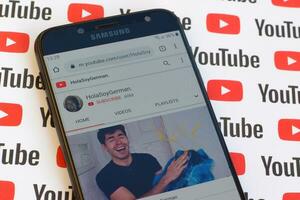HolaSoyGerman official youtube channel on smartphone screen on paper youtube background. photo