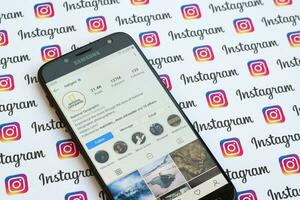 National Geographic official instagram account on smartphone screen on paper instagram banner. photo