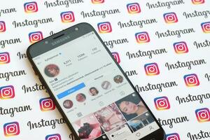 Kylie Jenner official instagram account on smartphone screen on paper instagram banner. photo