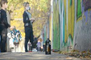 KHARKOV, UKRAINE - OCTOBER 19, 2019 Montana mtn black nc formula used spray can for graffiti painting outdoors in autumn leafs and artist in painting process photo