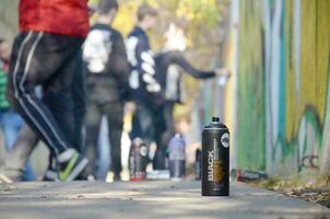 KHARKOV, UKRAINE - OCTOBER 19, 2019 Montana mtn black nc formula used spray can for graffiti painting outdoors in autumn leafs and artist in painting process photo