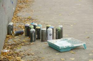 KHARKOV, UKRAINE - OCTOBER 19, 2019 Montana mtn 94 black hardcore dope and kobra used spray cans for graffiti painting outdoors in autumn leafs photo