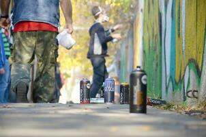 KHARKOV, UKRAINE - OCTOBER 19, 2019 Montana mtn black nc formula used spray can for graffiti painting outdoors in autumn leafs and artist in painting process photo