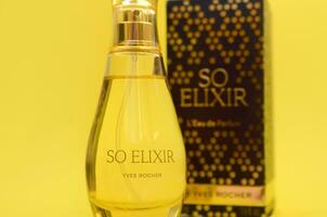 KHARKOV, UKRAINE - OCTOBER 21, 2019 Bottle of So Elixir perfume by Yves Rocher on bright yellow color background photo