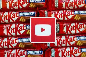 Youtube paper logo on many Kit Kat chocolate covered wafer bars in red wrapping. Advertising chocolate product in Youtube social network and world wide web photo