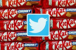 Twitter paper logo on many Kit Kat chocolate covered wafer bars in red wrapping. Advertising chocolate product in Twitter social network and world wide web photo