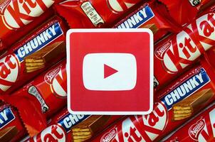 Youtube paper logo on many Kit Kat chocolate covered wafer bars in red wrapping. Advertising chocolate product in Youtube social network and world wide web photo