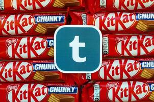 Tumblr paper logo on many Kit Kat chocolate covered wafer bars in red wrapping. Advertising chocolate product in Tumblr social network and world wide web photo