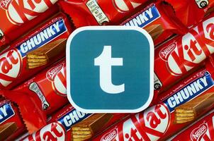 Tumblr paper logo on many Kit Kat chocolate covered wafer bars in red wrapping. Advertising chocolate product in Tumblr social network and world wide web photo