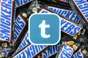 Tumblr paper logo on many Snickers chocolate covered wafer bars in brown wrapping. Advertising chocolate product in Tumblr social network and world wide web photo