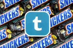 Tumblr paper logo on many Snickers chocolate covered wafer bars in brown wrapping. Advertising chocolate product in Tumblr social network and world wide web photo