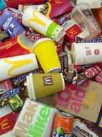 Many used food wrappings and drink cans by random food manufacturing famous brands. Recycled trash of treats and soda drinks photo