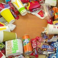 Many used food wrappings and drink cans by random food manufacturing famous brands. Recycled trash of treats and soda drinks photo