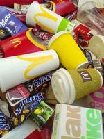 Many used food wrappings and drink cans by random food manufacturing famous brands. Recycled trash of treats and soda drinks photo