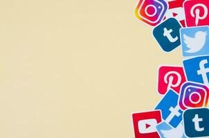 Many social network printed icons lies in pile on beige background with copy space. Facebook Instagram Pinterest Twitter Youtube Tumblr. Abstract internet background photo