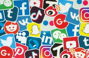 Many paper icons with logo of most popular social networks and smartphone apps for chat and conversations online photo