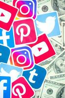 Many hundred dollars bills with printed logo of social networks. Facebook Instagram Youtube Tumblr Twitter Pinterest. Work using internet websites or apps photo