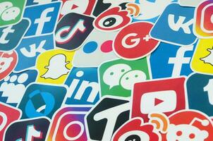 Many paper icons with logo of most popular social networks and smartphone apps for chat and conversations online photo