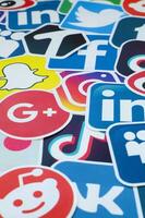 Many paper icons with logo of most popular social networks and smartphone apps for chat and conversations online photo