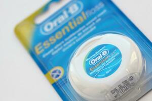 KYIV, UKRAINE - JULY 7, 2023 Oral-B Essentail Floss. Waxed dental floss in round case photo