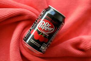 KYIV, UKRAINE - JULY 7, 2023 Dr Pepper cherry drink can on red background photo