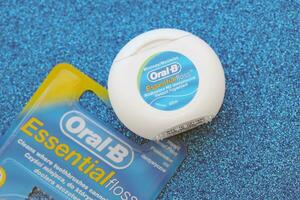 KYIV, UKRAINE - JULY 7, 2023 Oral-B Essentail Floss. Waxed dental floss in round case photo