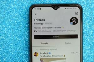 KYIV, UKRAINE - JULY 7, 2023 Threads by Meta application on display of Samsung smartphone lying on table photo