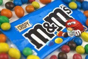 KHARKIV, UKRAINE - JANUARY 2, 2021 M and Ms colorful button shaped chocolate candies. Multi colored chocolates each of which has the letter m printed in lower case in white photo