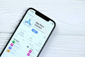 KHARKOV, UKRAINE - MARCH 5, 2021 App store connect icon and application from App store on iPhone 12 pro display screen on white table photo