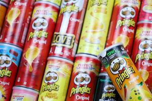 KHARKOV, UKRAINE - MARCH 30, 2021 Many Pringles cylinder chips boxes with varios colors and flavours. American brand of stackable potato-based crisps photo