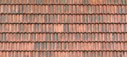 Close up of red terracotta roof shingles with some mildew. Background texture of roofing material photo