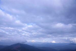 Morning view from the Dragobrat mountain peaks in Carpathian mountains, Ukraine. Cloudy and foggy landscape around Drahobrat Peaks photo