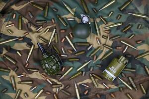 Different types of ammunition on a camouflage background. Preparing for war photo