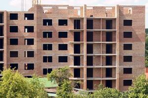 View of a large construction site with buildings under construction and multi-storey residential homes. Housing renovation photo