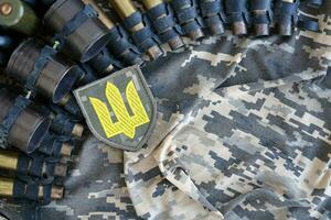 Ukrainian army symbol on machine gun belt lies on ukrainian pixeled military camouflage photo