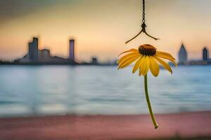 un amarillo flor cuelga desde un gancho en frente de un ciudad. generado por ai foto