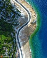 Empty Highway Amidst Lush Greenery and Natural Beauty, Captured From an Aerial Perspective Empty landscape with greenery, highway, tree, ocean, and natural beauty from above. photo