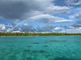 tranquilo escena vistoso arco iris terminado un sereno playa tranquilo isla paisaje con vistoso naturaleza y sereno atmósfera. foto